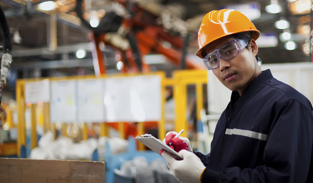 Asian industrial engineer writing down information