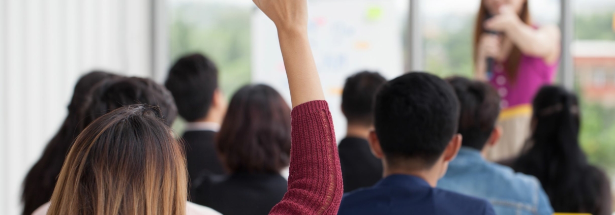 Woman raises hand during workplace training