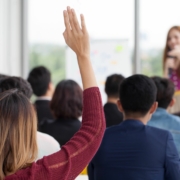 Woman raises hand during workplace training