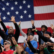 US flag behind a diverse group of campaign supporters